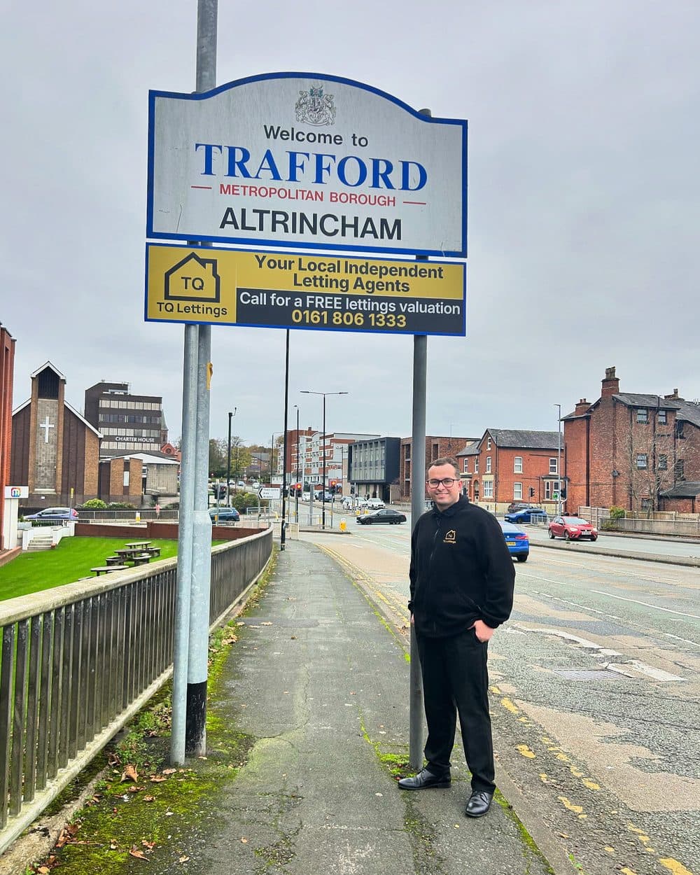 Will Tenquist beneath the Altrincham welcome sign on Manchester Road